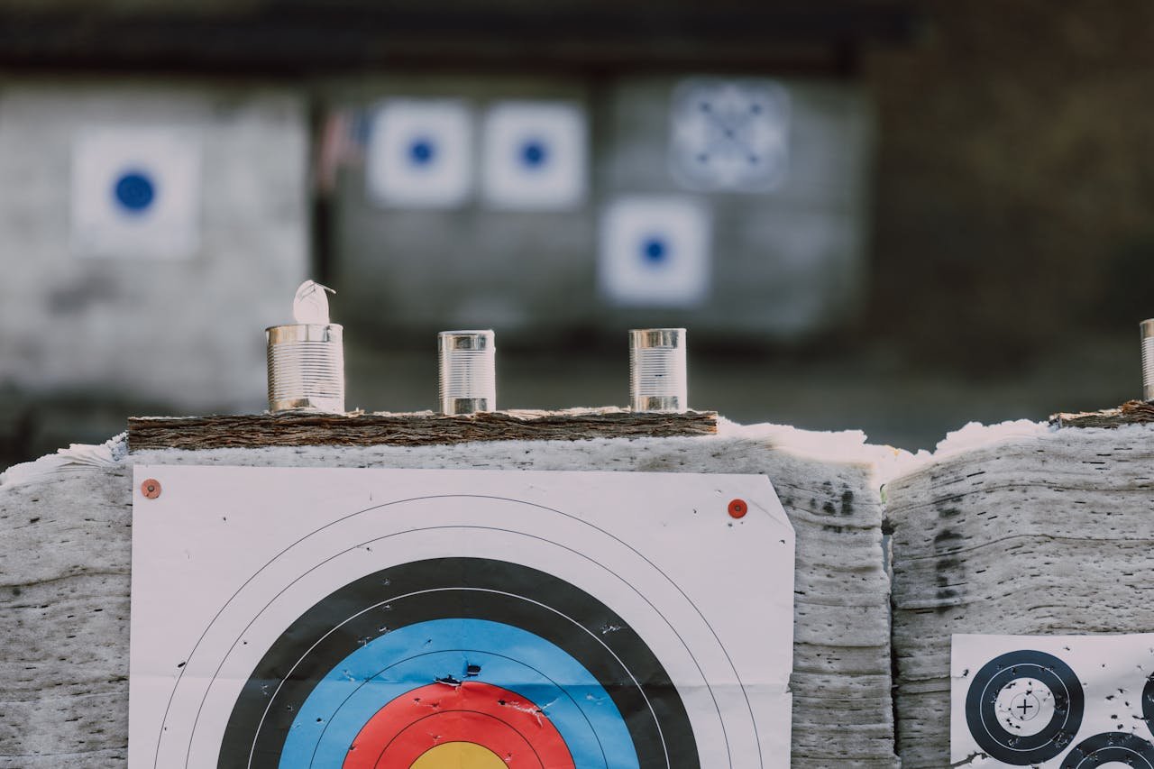 Close-up of archery targets and steel cans used for target practice at an outdoor range.